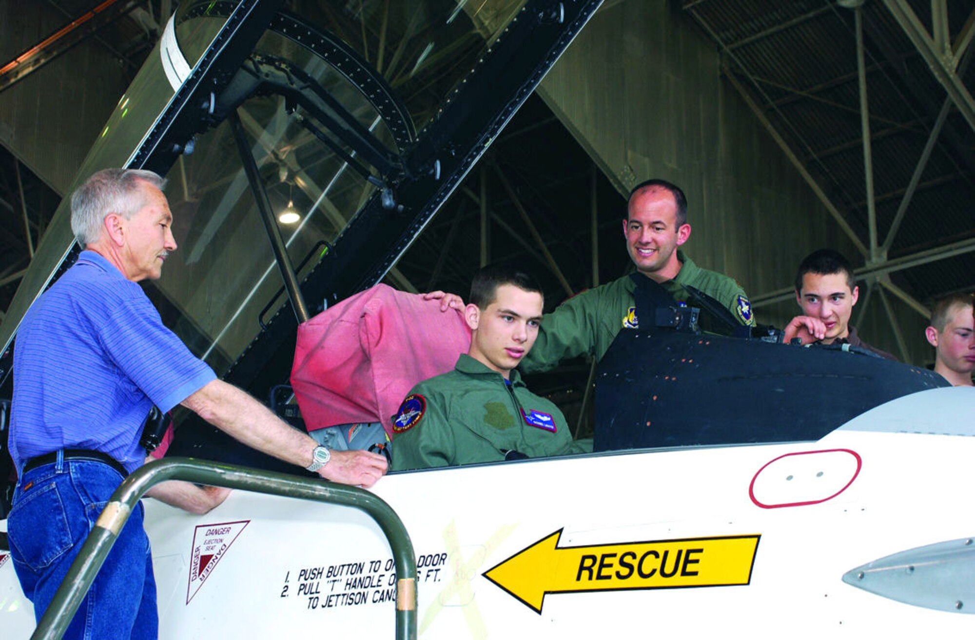 Maj. John Teichert, 411th Flight Test Squadron test pilot, seats Nathaniel LeMaster, 17, into the cockpit of an F-16 here Tuesday as part of Edwards "Pilot for a Day" program. Nathaniel was diagnosed with lymphoma in June and was granted his wish to experience what it's like to be a pilot through the Make-A-Wish Foundation. (Photo by Jet Fabara)