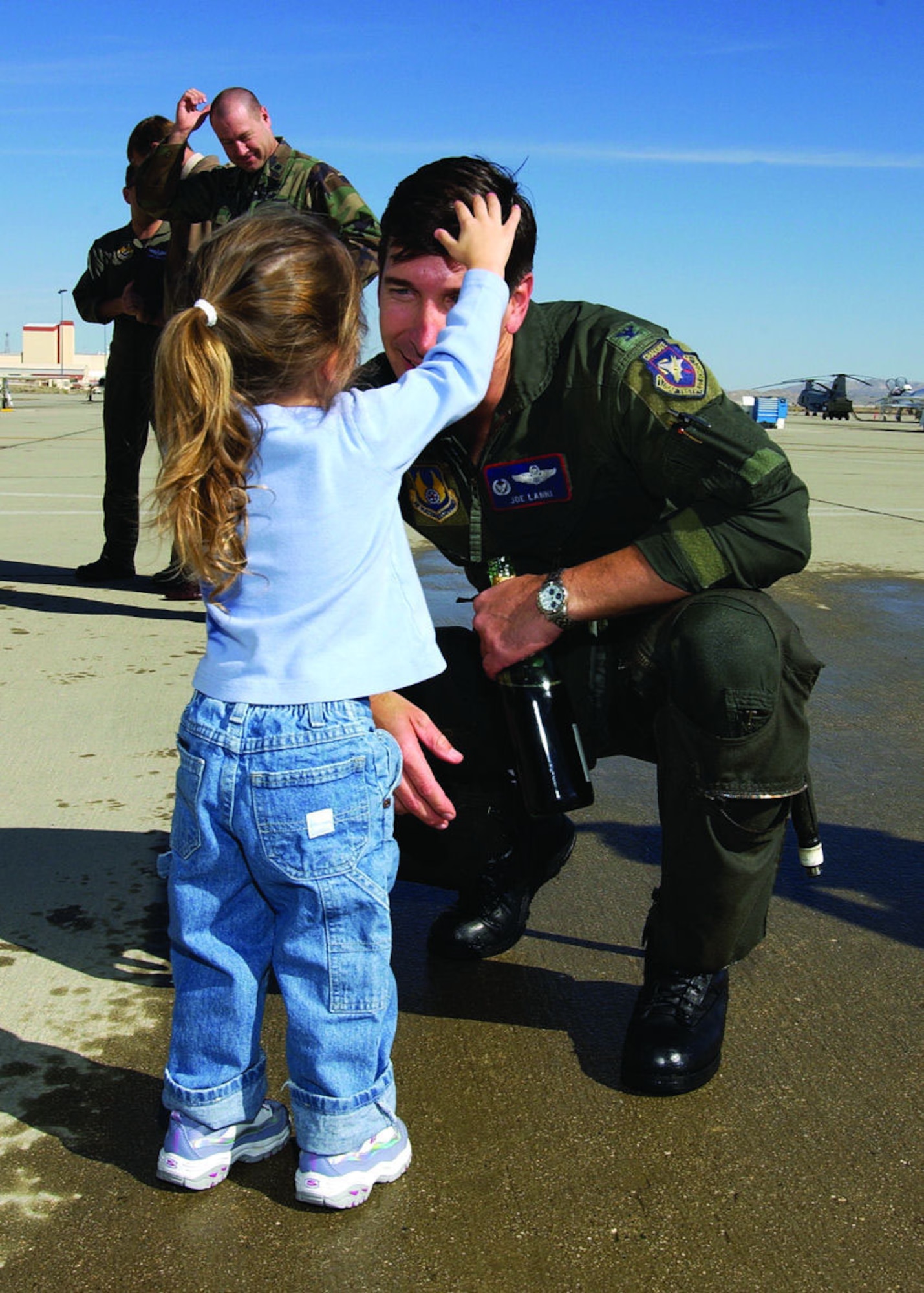 Col. Joe Lanni, then 412th Test Wing commander, smiles as his daughter, Michaela, 2, fixes his hair after being hosed down following his fini flight Jan. 31, 2006. Colonel Lanni passed command of the 412th TW to Col. Arnold Bunch on Feb. 2 in hangar 1600.  (Photo by Chad Bellay)