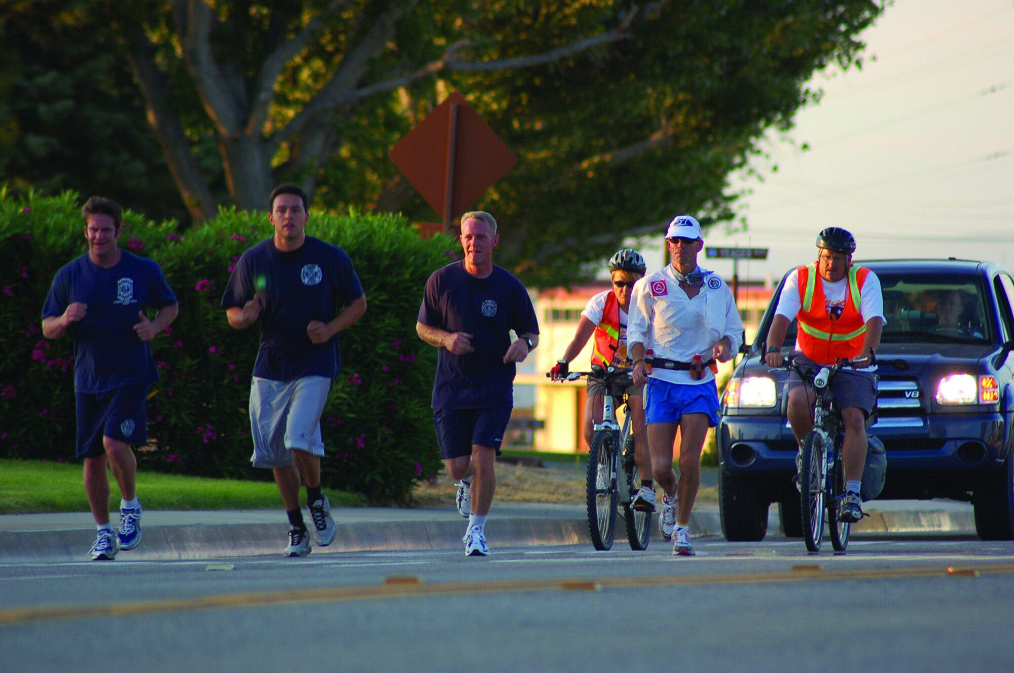 (From left to right) Edwards firefighters John Miller, Tyson Cardenas and Chris Lindsay run alongside former firefighter Ken Perry and two members from his medical team, bike riding, as Mr. Perry runs from the North Gate to the South Gate on June 2, 2006. Mr. Perry crossed Edwards as part of a 104.8-mile run benefiting the Wildland Firefighter Foundation, a non-profit organization that helps injured firefighters and the families of firefighters killed in the line of duty.  (Photo by Capt. Catie Hague)