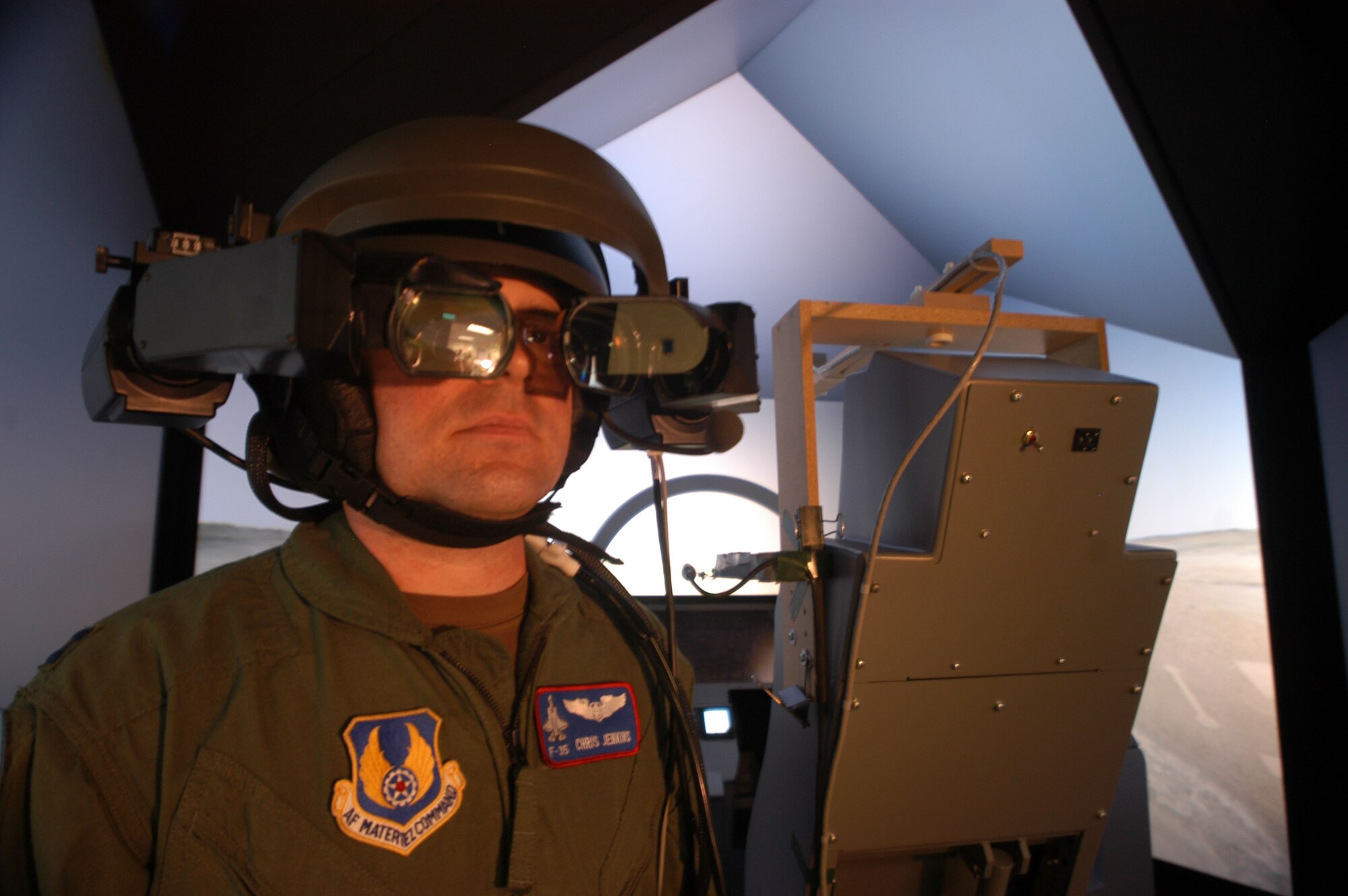 Capt. Chris Jenkins, Pilot Vehicle Interface lead for the F-35 Joint Strike Fighter Program Integrated Test Force, tries on the commercially available helmet-mounted display his team adapted for use with the JSF simulator. The team used the helmet for risk-reduction studies, which were completed June 20, 2006.  (Photo by Christopher Ball)