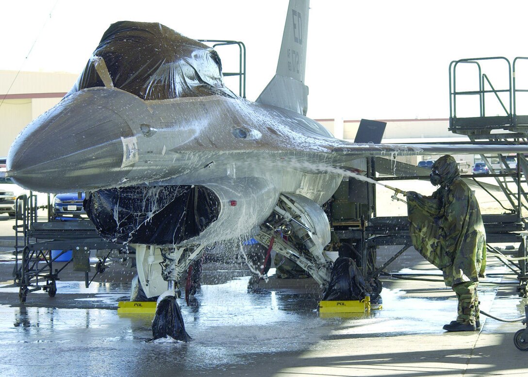 Members of the Joint Strike Fighter Integrated Test Force here prepare an F-16 for a final chemical decontamination test here Jan. 30, 2006. The F-16, used in place of an F-35, was sprayed with a chemical simulant, washed, then towed into a hangar and heated from 165- to 185-degree temperatures to accelerate the weathering of the remaining chemical. The goal of the testing is to decontaminate an entire aircraft to quickly return it to service should it be exposed to a chemical or biological agent. (Photo by Mark McCoy)