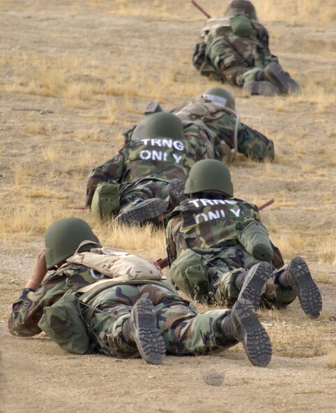 Airmen low crawl and take cover during the defensive maneuver training at Camp Corum, July 26, 2006. The day-long excursion also featured a Self Aid Buddy Care refresher course taught by the 95th Medical Group staff, unexploded ordnance searches and proper reporting procedures by the Explosive Ordnance Disposal Division.   (Photo by Mike Cassidy)