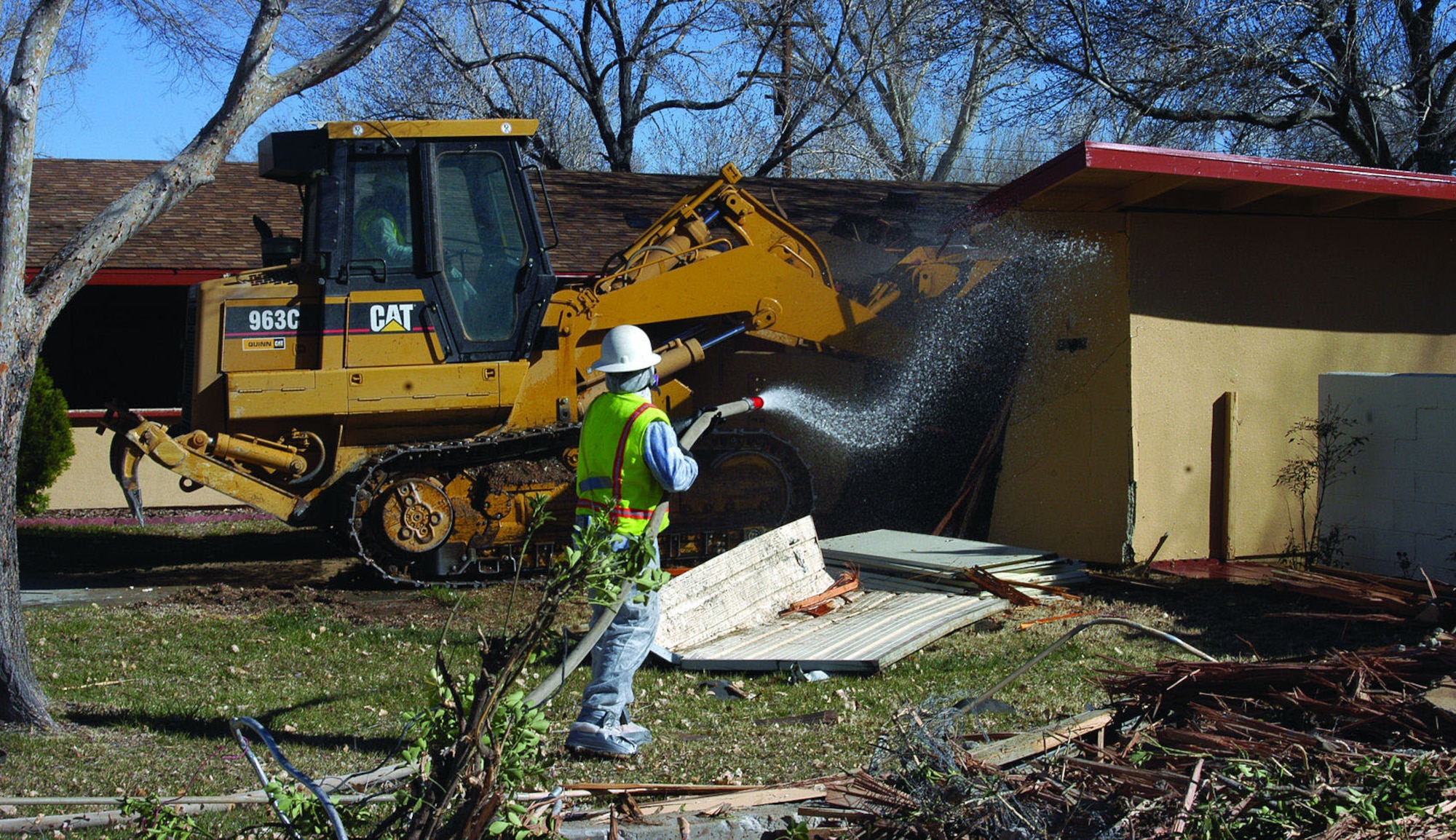 Employees of Flores Sierra Contractors Inc. demolish a house on Chanute Drive in the Mesquite Meadows housing area, March 21, 2006. Demolition of the Mesquite Meadows housing units began Feb. 1, and is scheduled to be complete by April 1. Construction of new units in the area is scheduled to begin in April.  (Photo by Christopher Ball)
