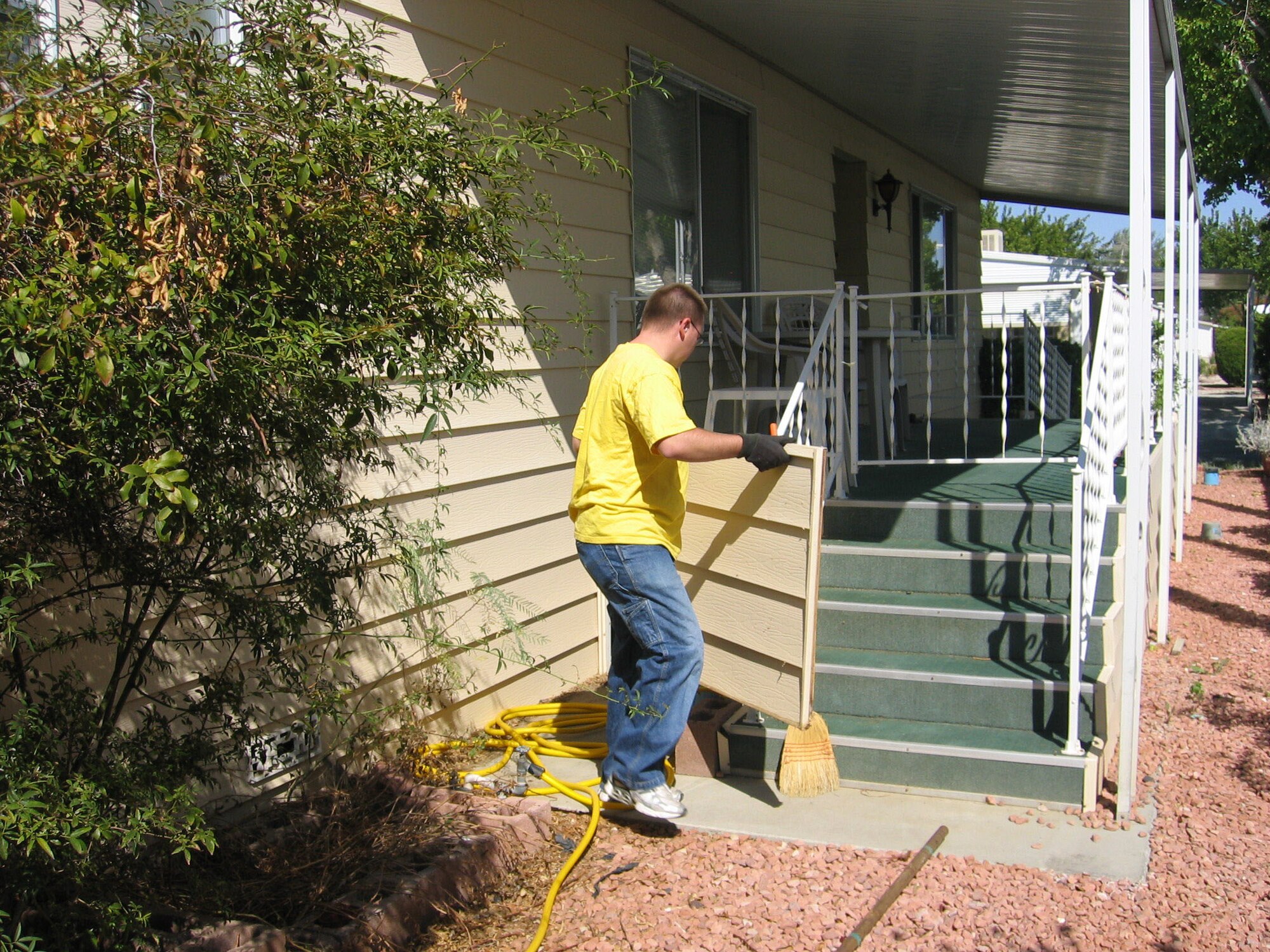 Airman 1st Class Jonathan Tuck, 412th Maintenance Squadron missile maintenance crew member, removes and cleans vinyl siding to help senior citizens repair their homes in the local community.  (Photo by Staff Sgt. Jessie Gregorio)