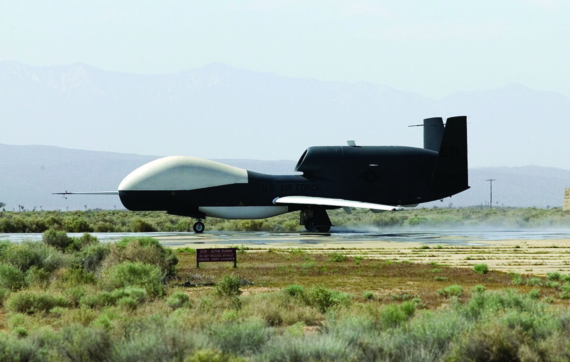 A Global Hawk unmanned aerial vehicle performs a high-speed taxi test on South Base here during Phase III of wet runway testing May 3, 2006. This is the first time wet runway tests have been conducted with a UAV.  (Photo by Bobbi Zapka)