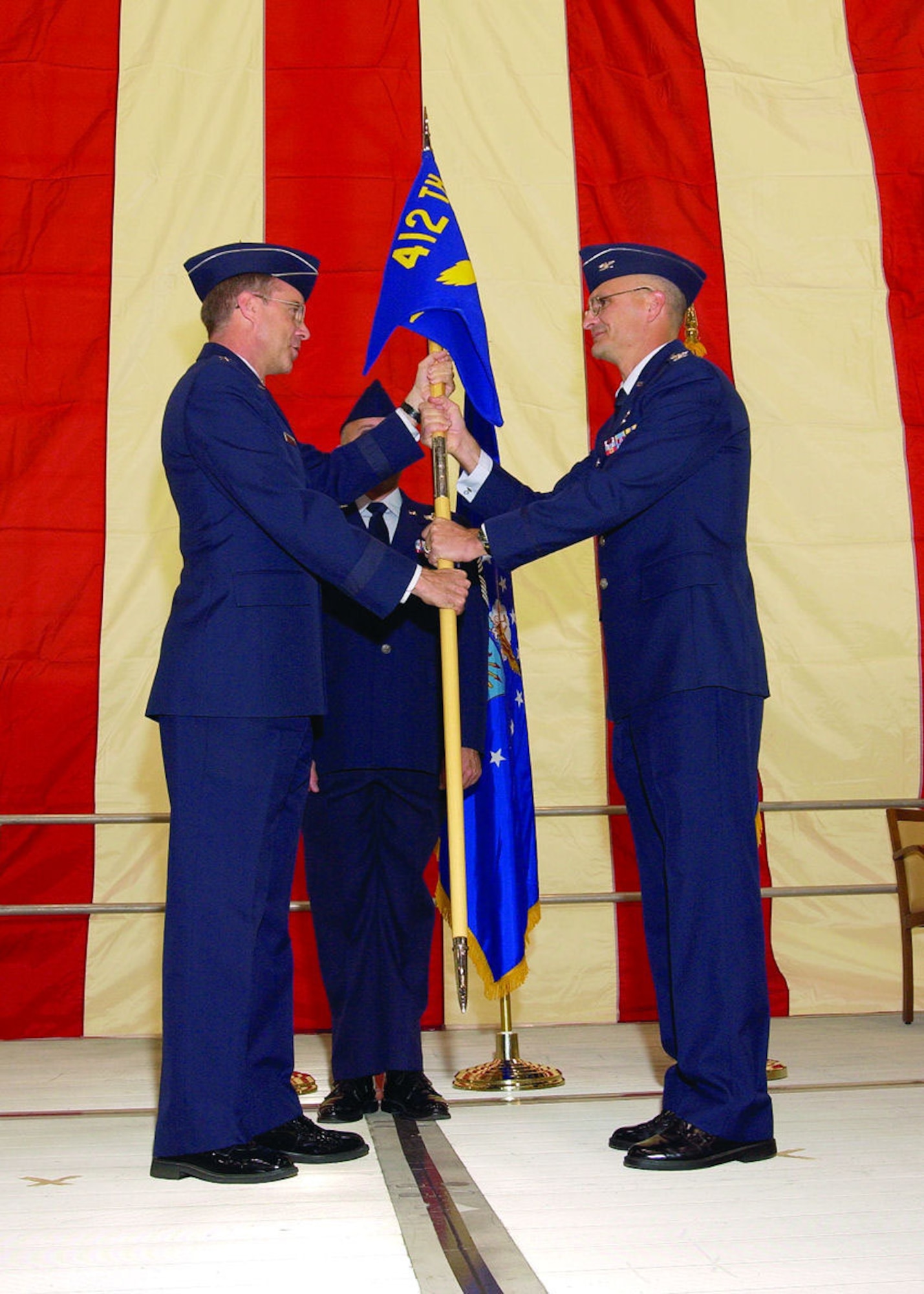Maj. Gen. Curtis Bedke, Air Force Flight Test Center commander (left), hands the command flag to Col. Arnie Bunch, 412th Test Wing commander, during the test wing change of command ceremony here, Feb. 2, 2006.  (Photo by Chad Bellay)