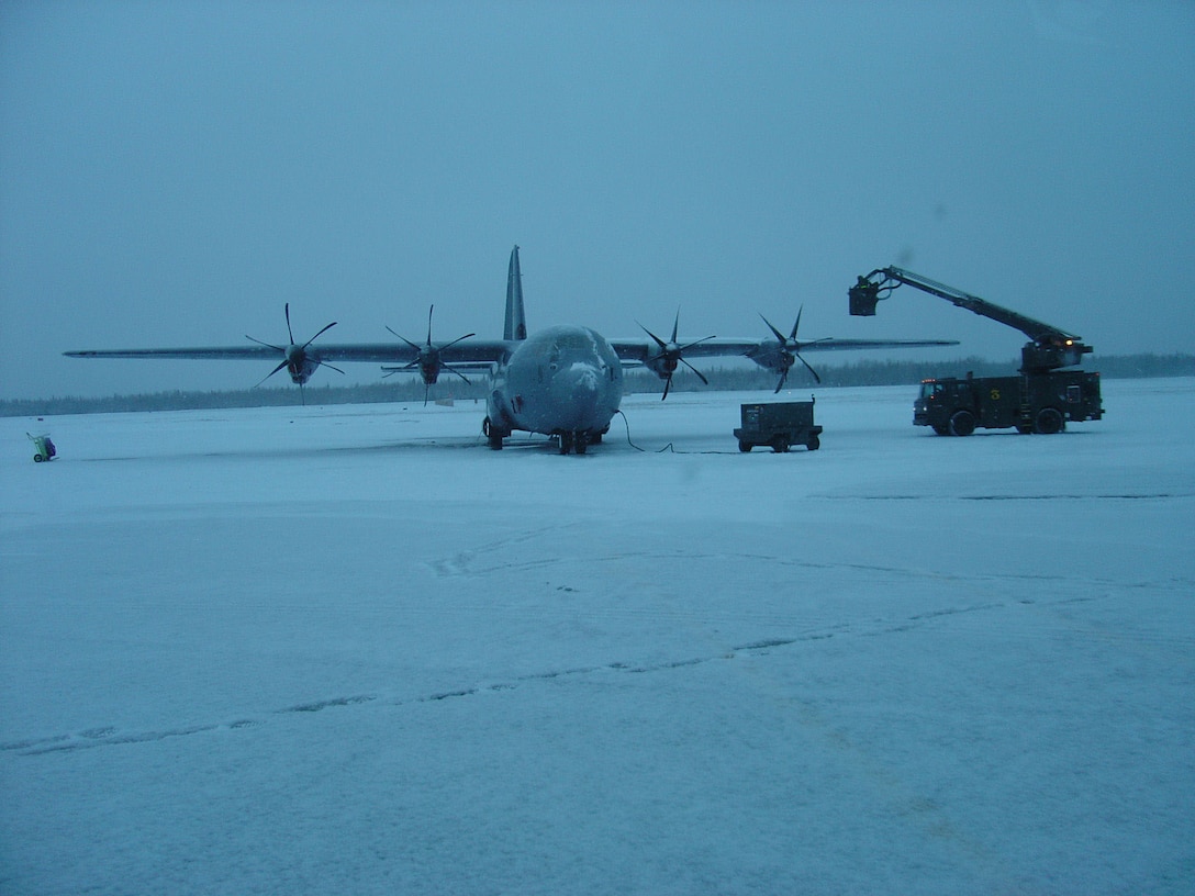A C-130J is de-iced at Eielson Air Force Base, Alaska, during Phase 2 Operational Test and Evaluation flight test studies. The deployment of the C-130J to Eielson was designed to test the aircraft and its avionics' ability to continue its mission through extreme weather conditions. (Photo by 1st Lt. Thomas Harner)