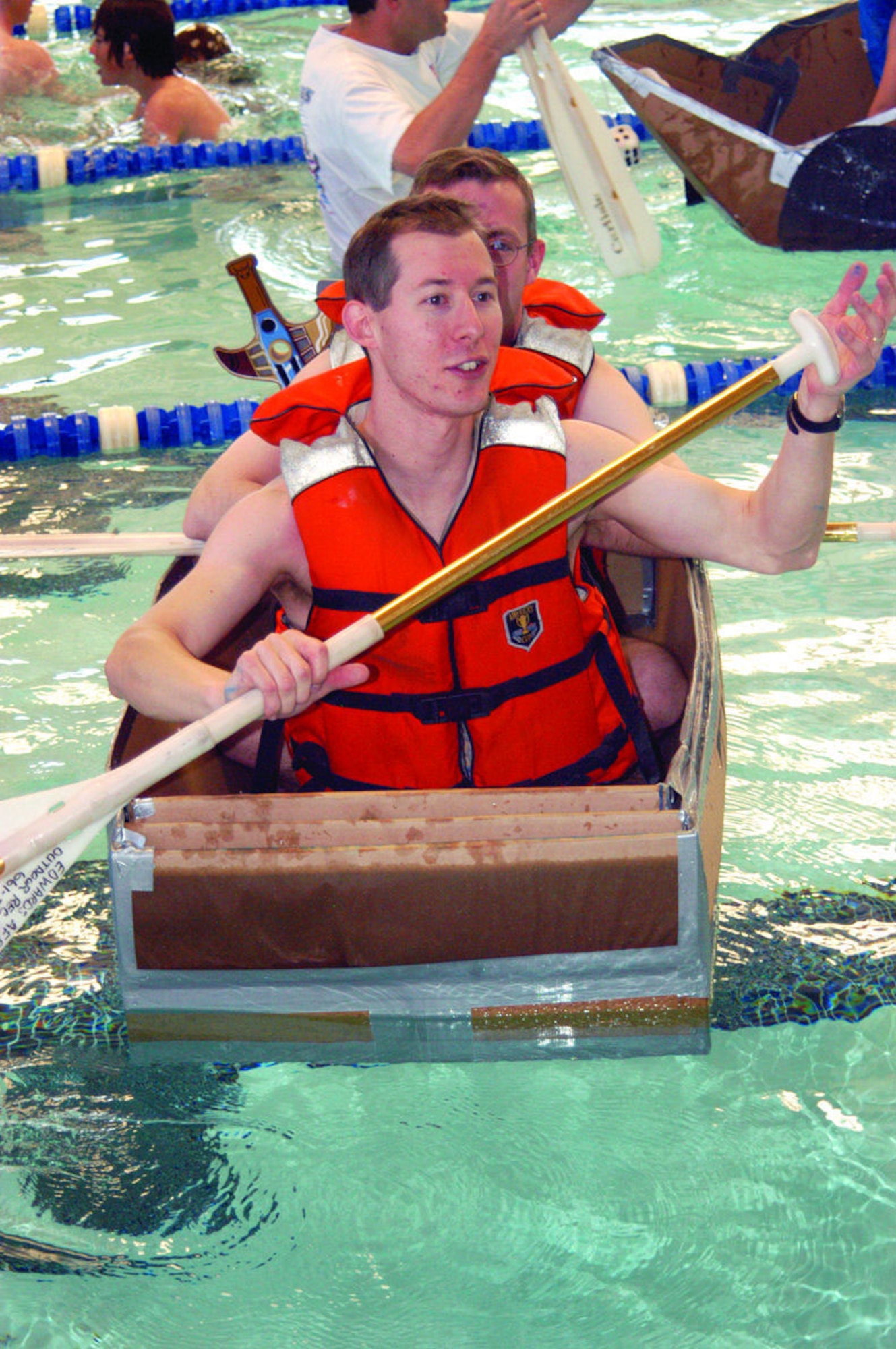 "Thr33 Ti3r Tug of Terror" team members Brad DeVries and E.T. Waddell celebrate after finishing first place on the Build-a-Boat Competition race Feb. 11, 2006, at the Oasis Aquatic Center here. Build-a-boat is an annual event where competitors build a boat within two hours and then race it two-full lengths of an Olympic-size pool.  (Photo by Airman 1st Class Julius Delos Reyes)