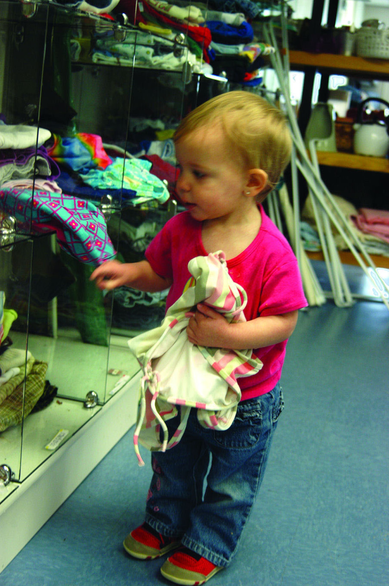 Shelby Taylor, 13 months, browses the clothing section in the children's area of the Airmen's Attic on March 31. Families of first- and second-term Airmen are allowed up to 40 items per month.  (Photo by Senior Airman Francesca Carrano)