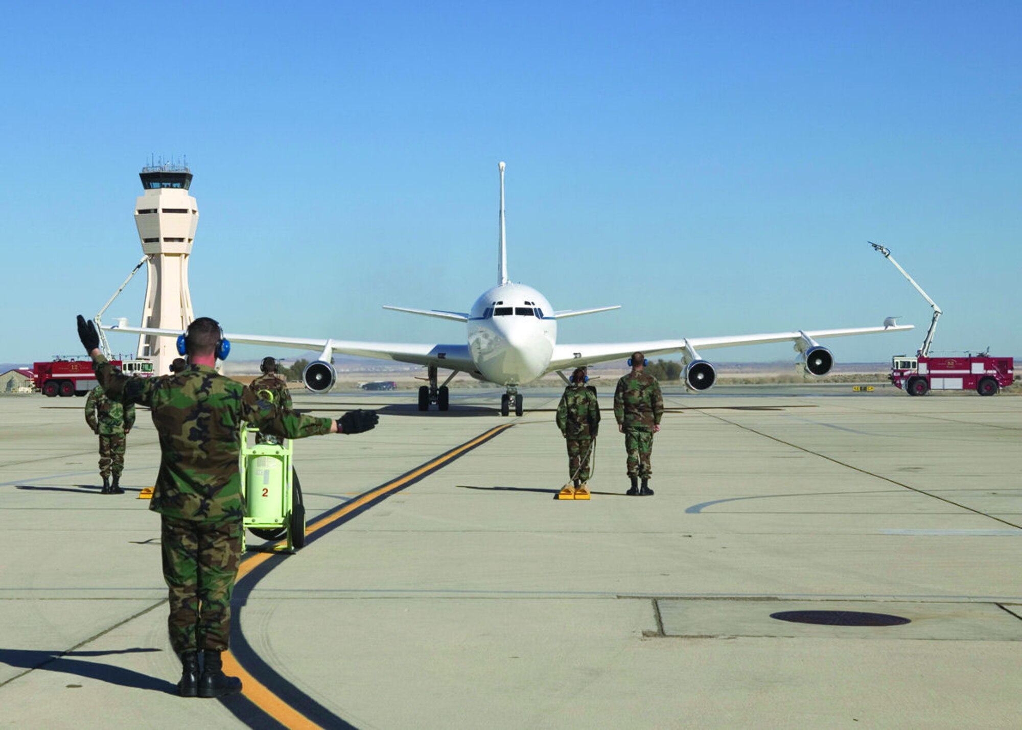 Crew members of the C-135C tail number 669, also known as Speckled Trout, watch the aircraft complete its fini-flight after taxiing underneath the fire department water cascade on Jan. 13, 2006.  (Photo by Bobbi Zapka)