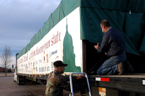 Tech. Sgt. Roger Salinas assists driver Gordy Grove in tying down the flap on the back of the truck Nov. 21 after Airmen from 90th Civil Engineer Squadron fire department watered the 2006 Capitol Christmas Tree being transported to Washington D.C. The tree stopped at F.E. Warren Air Force Base, Wyo., on its way to the nation's capital.  Sergeant Salinas is assigned to the 90th CES.  (U.S. Air Force photo/1st Lt. Josh Edwards)