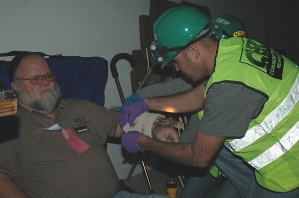 Senior Airman Nick Bluter, 741st Missile Security Forces Squadron, treats a patient's wounds at the simulated disaster site. 