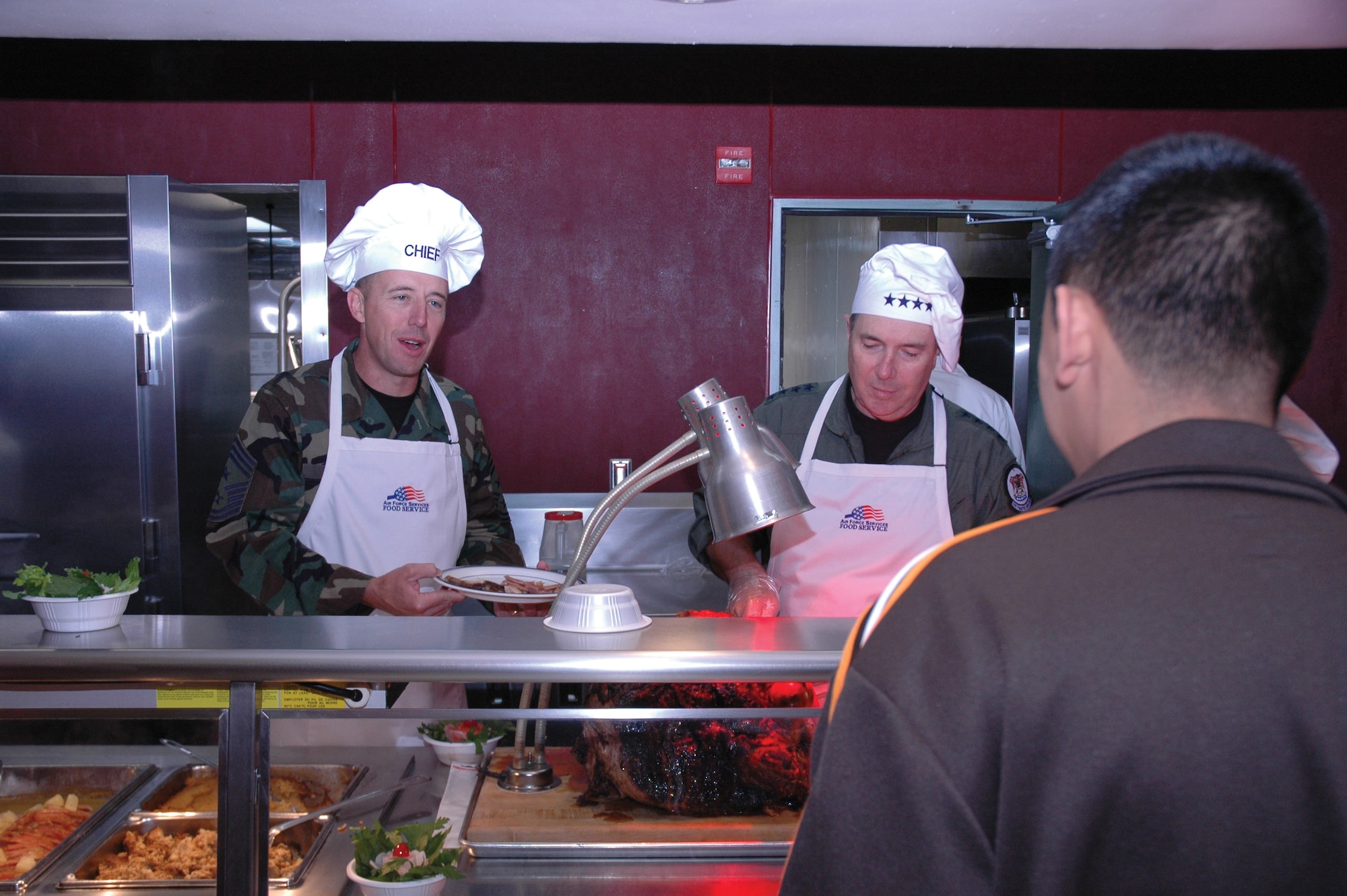 Gen. Paul V. Hester (right), Pacific Air Forces commander, and Chief Master Sgt. Anthony Bishop, PACAF command chief master sergeant, serve Thanksgiving meals to Airmen at Osan Air Base, South Korea, Nov. 23. (U.S. Air Force photo/1st Lt. Kevin Coffman)
