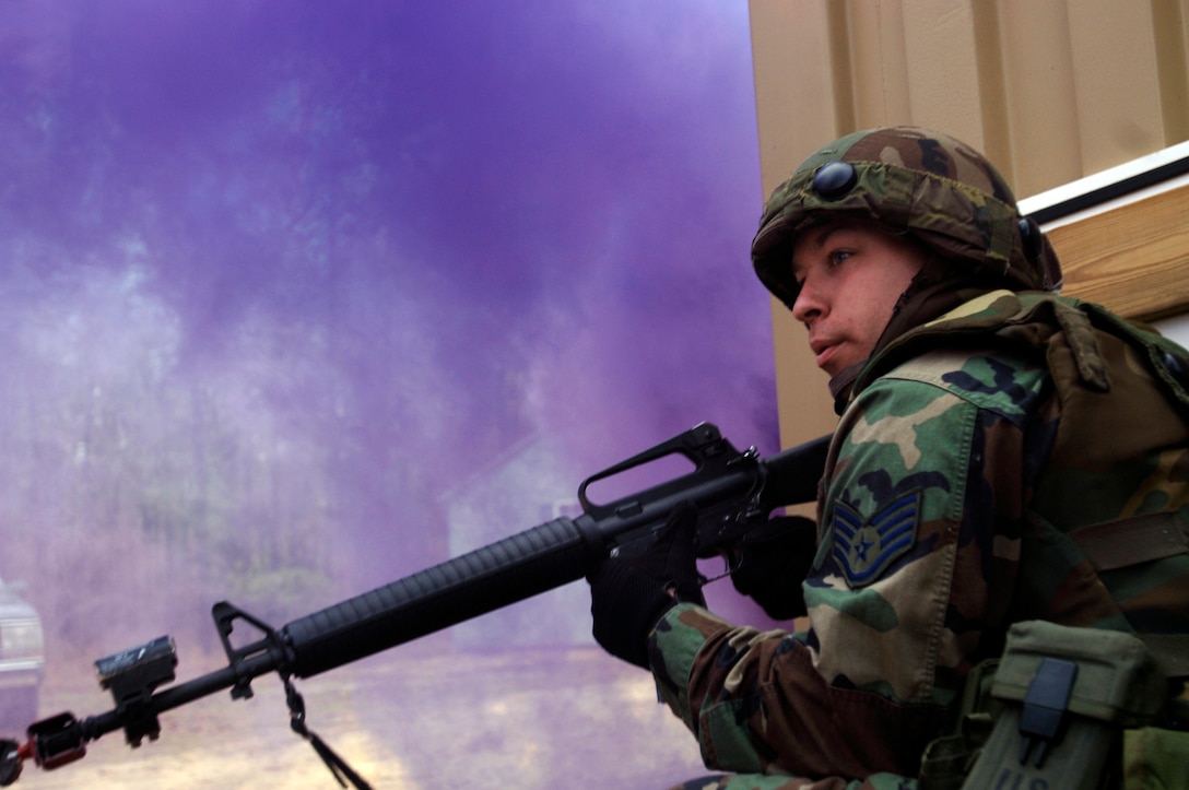 Staff Sgt. James Smith takes cover while purple smoke bombs and gunfire rain upon his position from simulated insurgents during the Contingency Skills Training course at the Air Mobility Warfare Center at Fort Dix, N.J., Nov. 14. (U.S. Air Force photo/Tech. Sgt. Cecilio M. Ricardo Jr.)