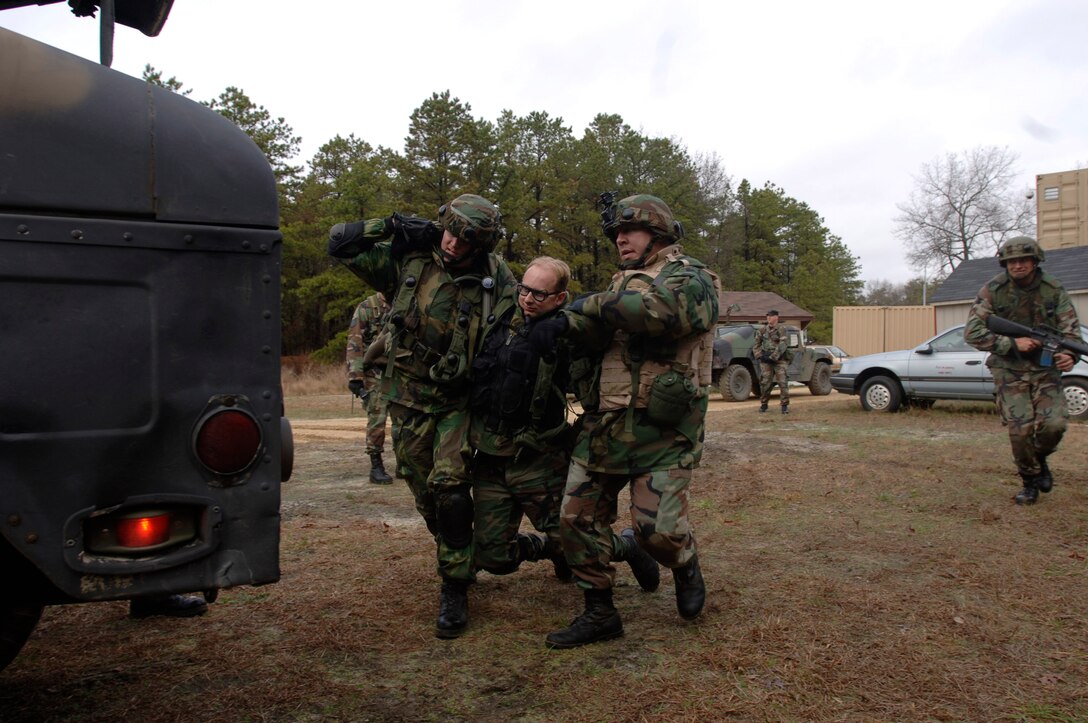 Capt. Mark McKellen and Capt. Ken Hall carry a "wounded" Staff Sgt. Isaac Ball to a Humvee during the Contingency Skills Training course at the Air Mobility Warfare Center at Fort Dix, N.J., Nov. 14. (U.S. Air Force photo/Tech. Sgt. Cecilio M. Ricardo Jr.)