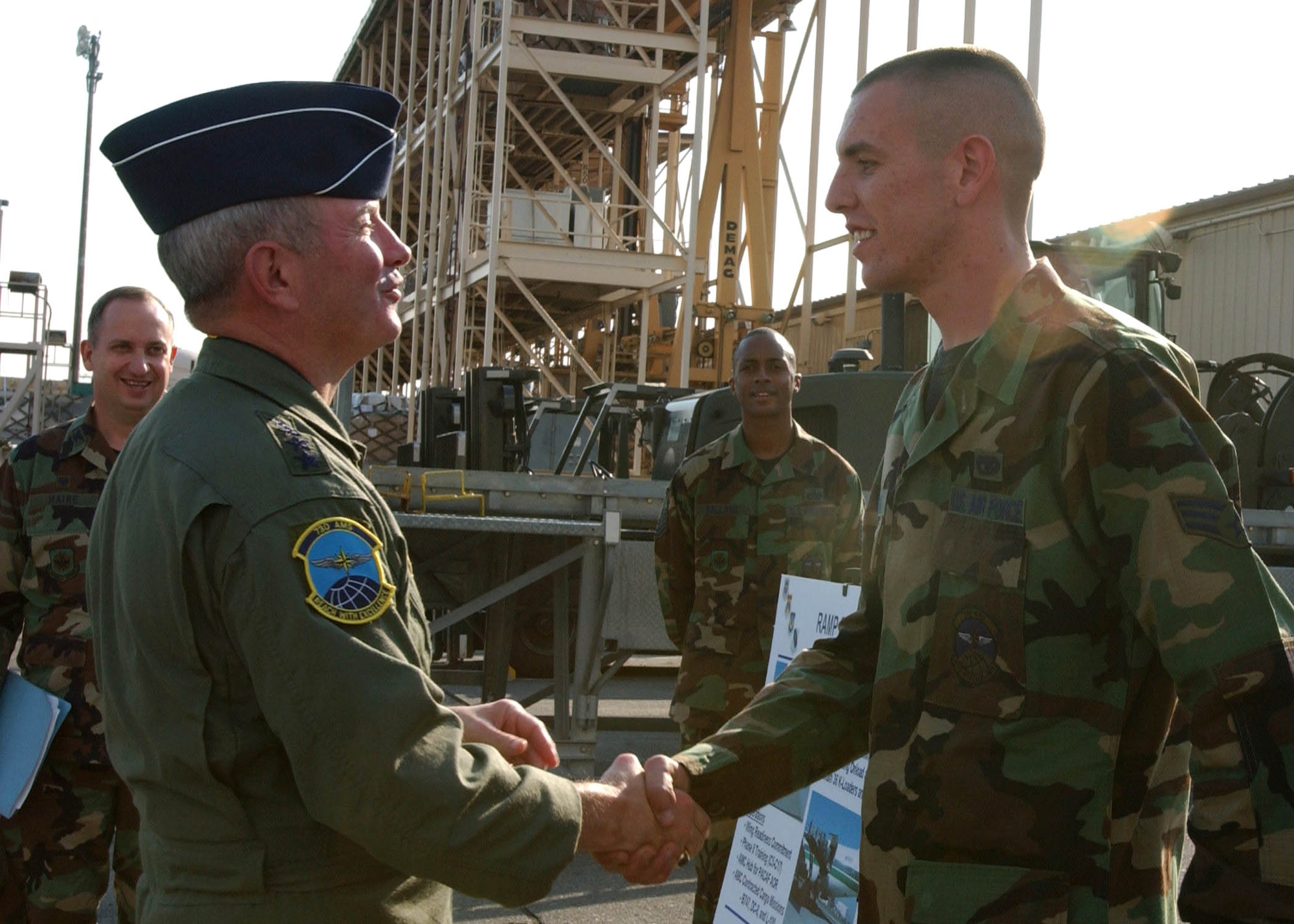 Gen. Duncan J. McNabb, Air Mobility Command commander, coins Senior Airman David Hagan, 730th Air Mobility Squadron ramp services technician, during his visit at Yokota Air Base, Japan, Nov. 16. (U.S. Air Force photo/Airman 1st Class Brian Kimball) 
