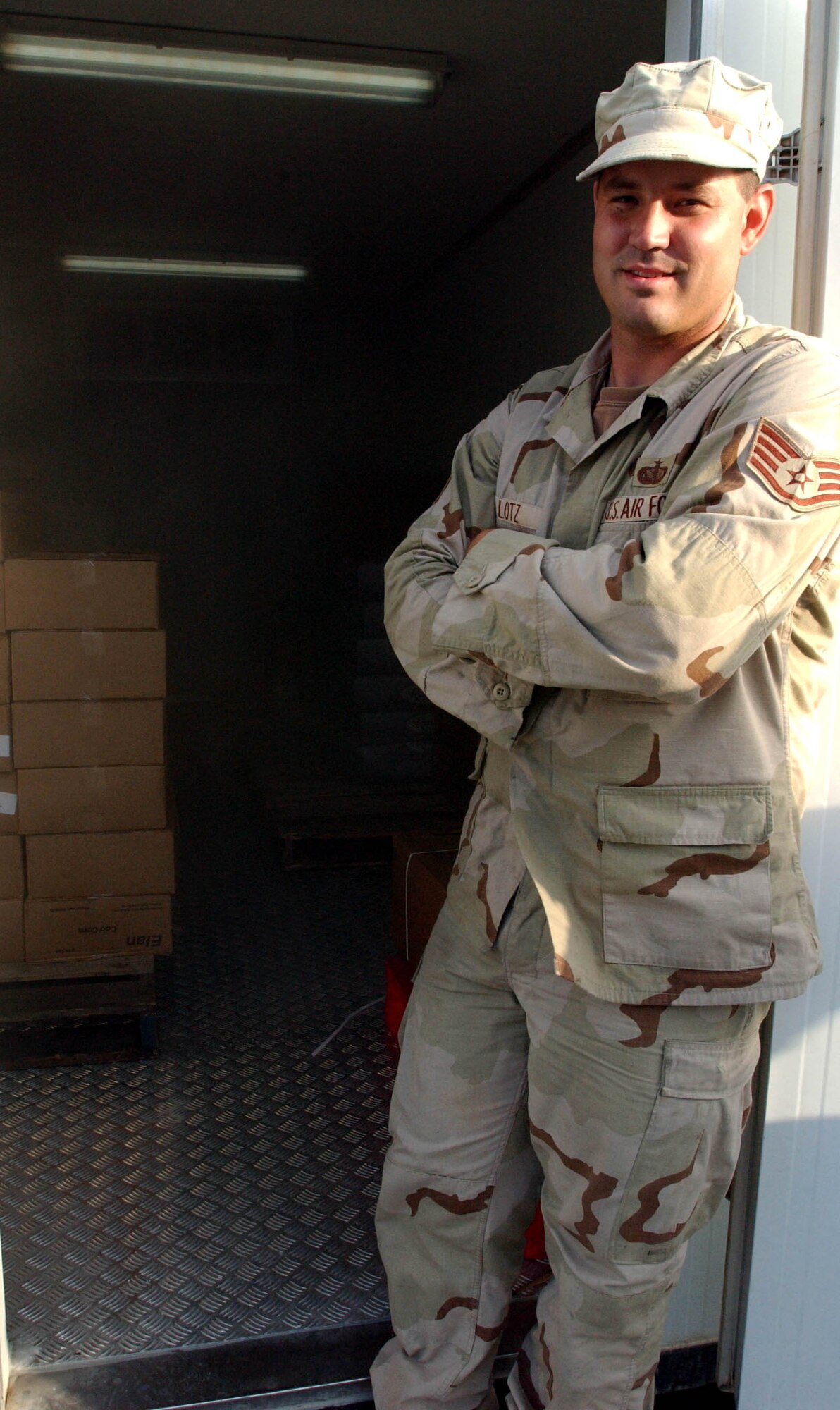 Staff Sgt. James Lotz, 380th Expeditionary Services Squadron, stands next to a freezer containing about two tons of pies, vegetables and more. Sergeant Lotz ordered better than $25,000 worth of food for the 380th Air Expeditionary Wing's Thanksgiving feast. (U.S. Air Force photo/Master Sgt. Jason Tudor)

