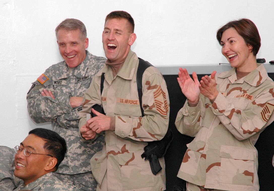 Servicemembers react to a song during a performance by Michael Peterson, a country music singer visiting Afghanistan courtesy of the USO, Nov. 23, 2006. Peterson performed a comical song about the secret to a successful marriage during his visit to Forward Operating Base Gardez, Afghanistan.