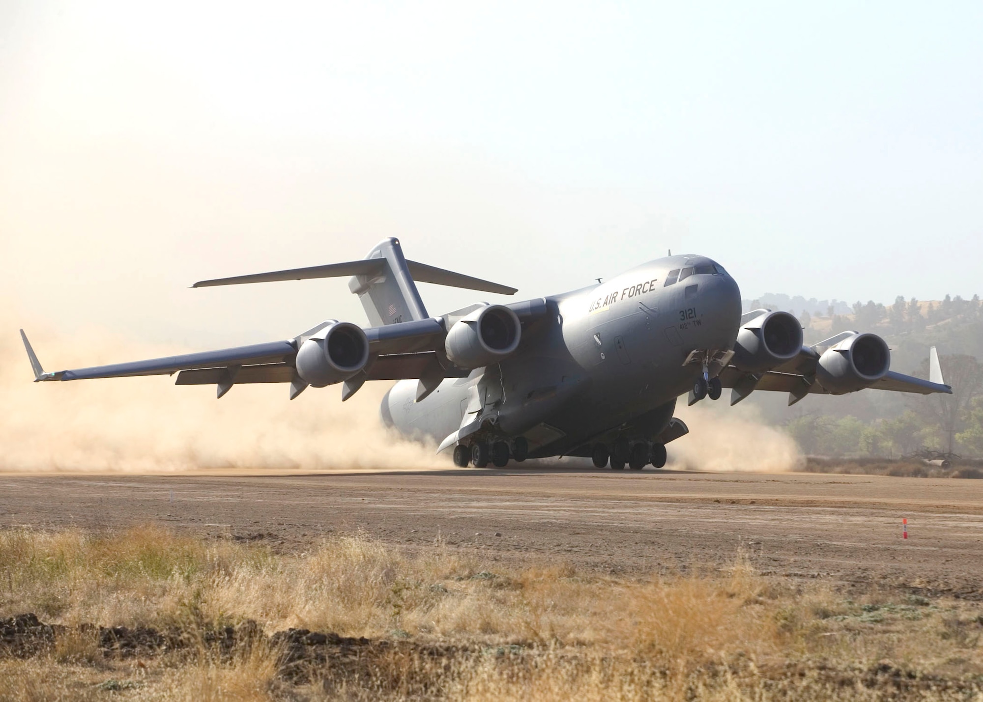 A C-17 Globemaster III takes off during Phase 1 tests at Fort Hunter Liggett, Calif. Tests are being conducted to determine the C-17's ability to bring a large force into a wet or dry dirt airfield without making runway condition corrections. Phase 2 is scheduled to begin Dec. 4 at Edwards Air Force Base, Calif. (U.S. Air Force photo/Bobbi Zapka) 