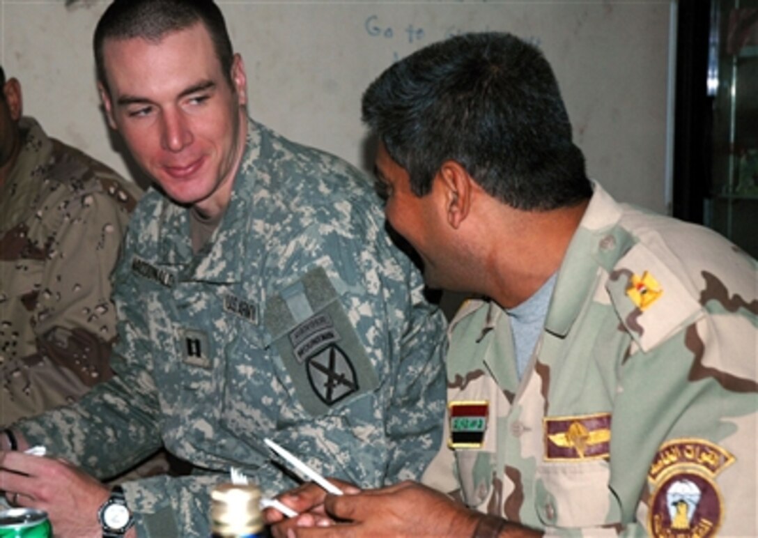 U.S. Army Capt. Christopher McDonald, left, 10th Mountain Division, speaks with Iraqi Maj. Mahssen as they celebrate Thanksgiving in Yusufiyah, Iraq, Nov. 23, 2006.