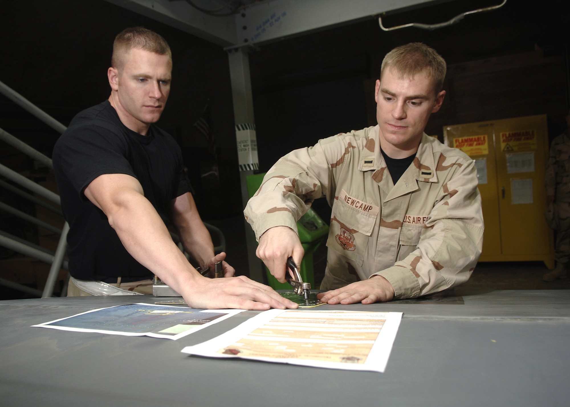 Staff Sgt. Shawn Krah (left), an aircraft structural maintenance craftsman with the 379th Expeditionary Maintenance Squadron, discusses one-time flight options for a damaged flap on a B-1 Lancer with 1st Lt. Jeffrey Newcamp, a depot liaison engineer with the 379th Expeditionary Maintenance Operations Squadron. (U.S. Air Force photo/Senior Airman Ricky Best) 