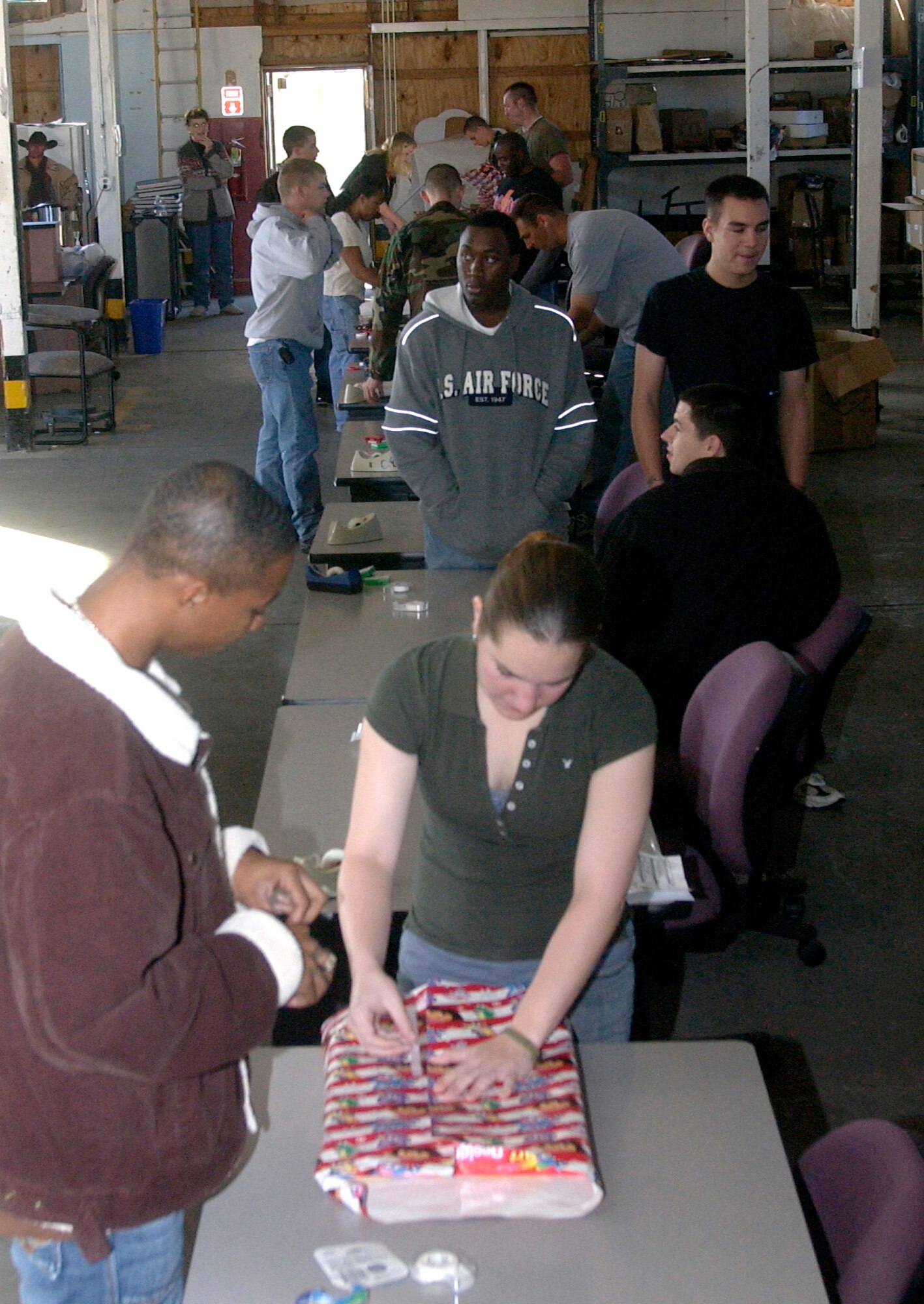 Volunteers from all around the base gather in a Vandenberg warehouse Nov. 18 to help wrap Christmas presents for Operation Kids Chistmas.  The event offers Christmas gifts to more than 200 underprivledged children in the local communities.  (U.S. Air Force Photo by Airman 1st Class Nathaniel Prost)                                                                                                      