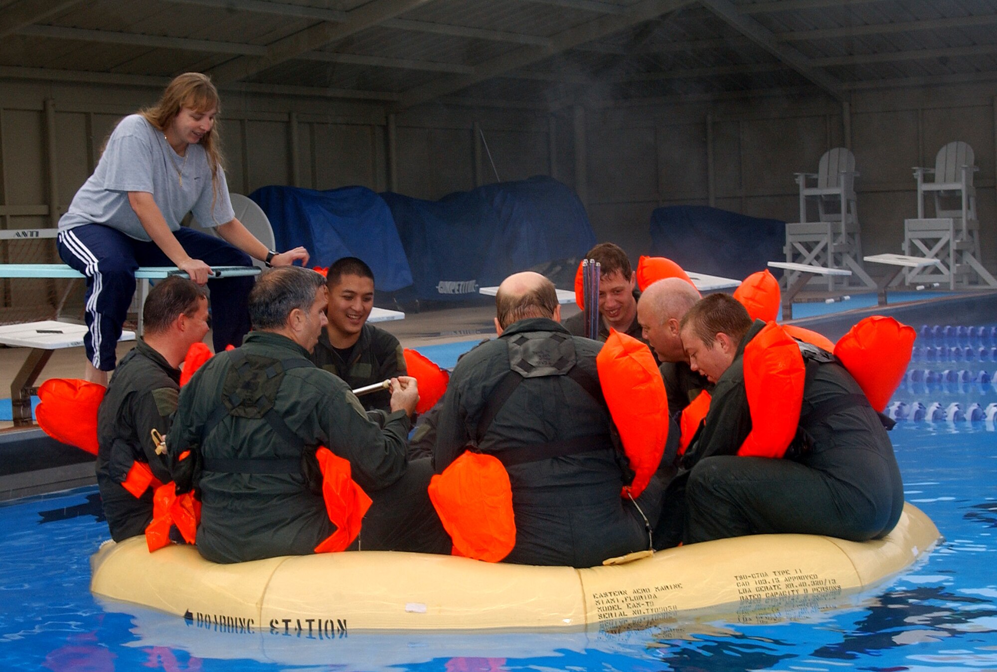 Staff Sgt. Sharon Saxon, 76th Helicopter Squadron, instructs a simulated downed helicopter crew aboard a life raft Nov. 22 in Vandenberg's base pool.  The life raft is used to keep crew members afloat after escaping a downed aircraft submerged in water where they would remain until rescue workers arrive.  (U.S. Air Force Photo by Airman Adam Guy)                                                                      
