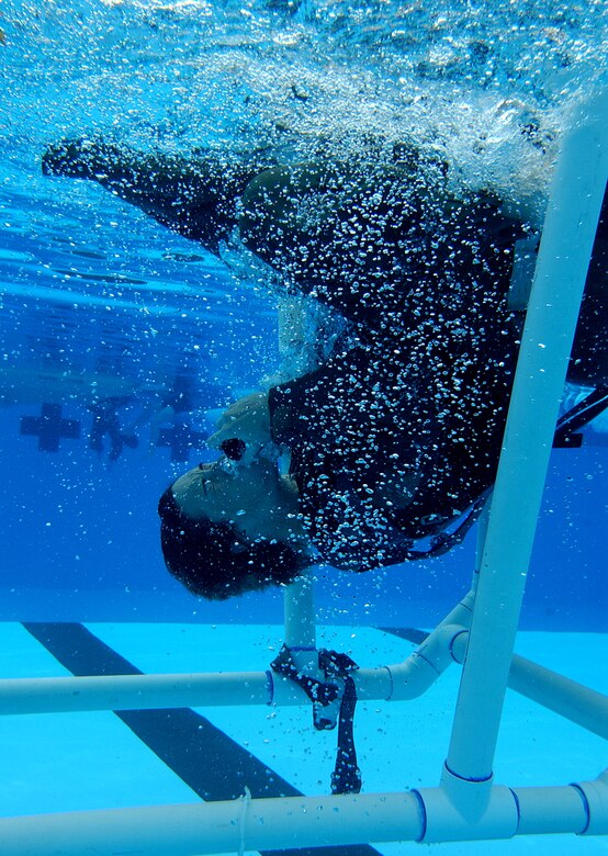 1st Lt. Abbe Shafer, 76th Helicopter Squadron pilot,  is flipped over in an underwater egress training chair Nov. 22 in Vandenberg's base pool.  The exercise is used to simulate escaping from an underwater helicopter crash.  (U.S. Air Force photo by Senior Airman Vanessa Valentine)
