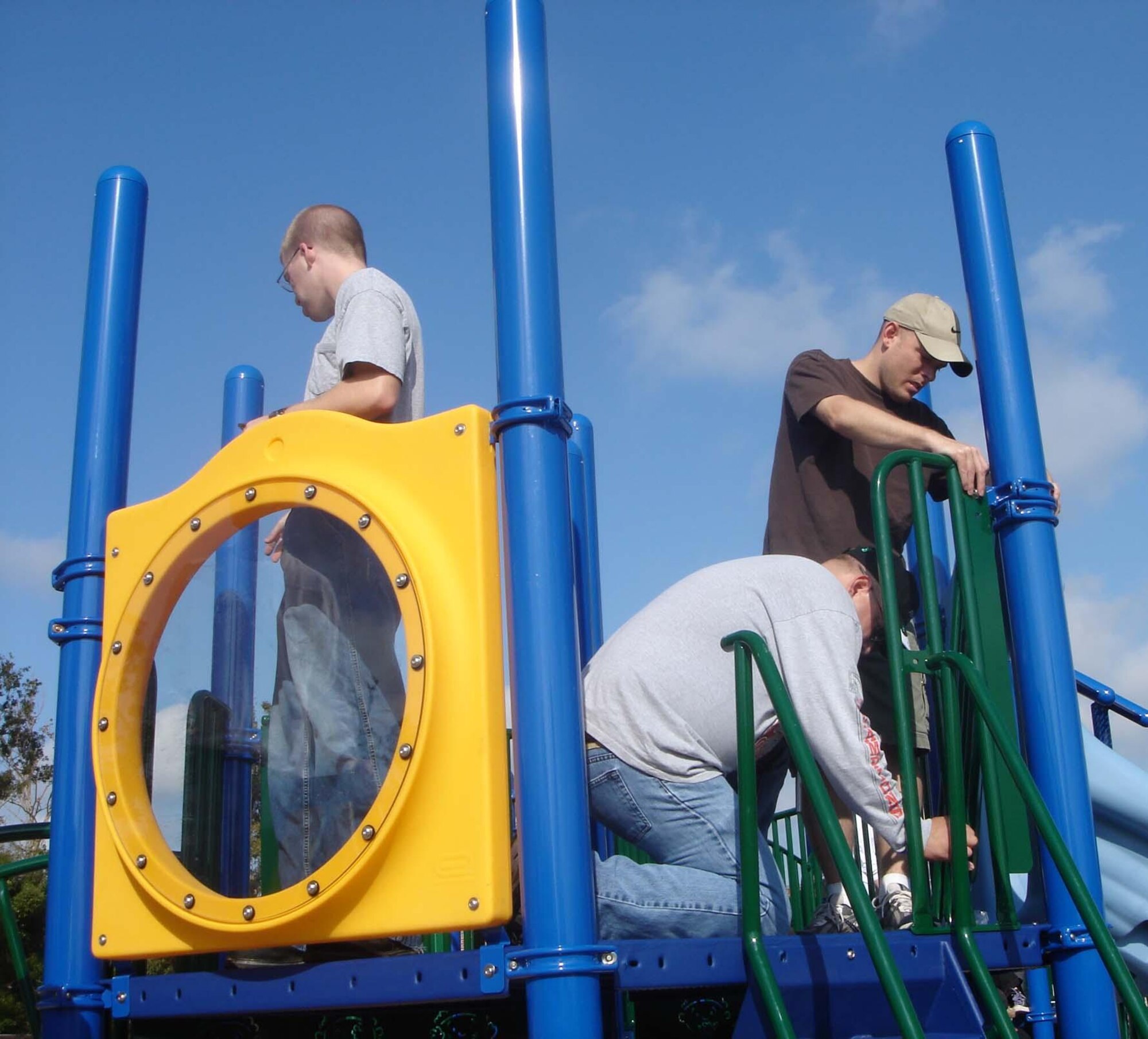 From left, Senior Airman Arron Eden, Tech. Sgt. Brian Yelton and Master Sgt. John Baliey put finishing touches on playground equipment at Gorenflo Elementary School in Biloxi. The trio and 17 other members of the 81st Training Support Squadron gave up their Nov. 11 for the humanitarian project. (U.S. Air Force photo by Maj. Paul Lips)
