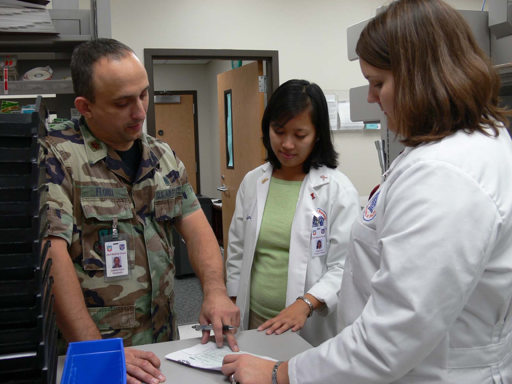 MOODY AIR FORCE BASE, Ga. -- Maj. (Dr.) Gabriel Florit, 23rd Medical Support Squadron pharmacy clinical coordinator here, talks with Quyen Cai, pharmacy drug information services intern, and Carla Barber, pharmacy adult medicine intern, about a patient’s prescription. Moody’s pharmacy is currently training four pharmacy students from the University of Florida’s Doctorate of Pharmacy program. Moody also has a contract with the University of Georgia and Mercer University. (U.S. Air Force photo by Senior Airman Leticia Hopkins)