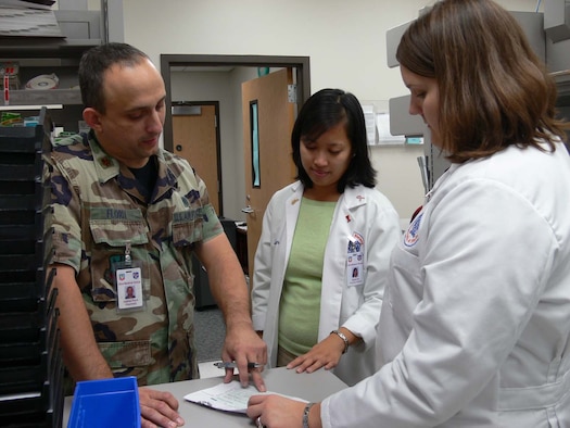 MOODY AIR FORCE BASE, Ga. -- Maj. (Dr.) Gabriel Florit, 23rd Medical Support Squadron pharmacy clinical coordinator here, talks with Quyen Cai, pharmacy drug information services intern, and Carla Barber, pharmacy adult medicine intern, about a patient’s prescription. Moody’s pharmacy is currently training four pharmacy students from the University of Florida’s Doctorate of Pharmacy program. Moody also has a contract with the University of Georgia and Mercer University. (U.S. Air Force photo by Senior Airman Leticia Hopkins)