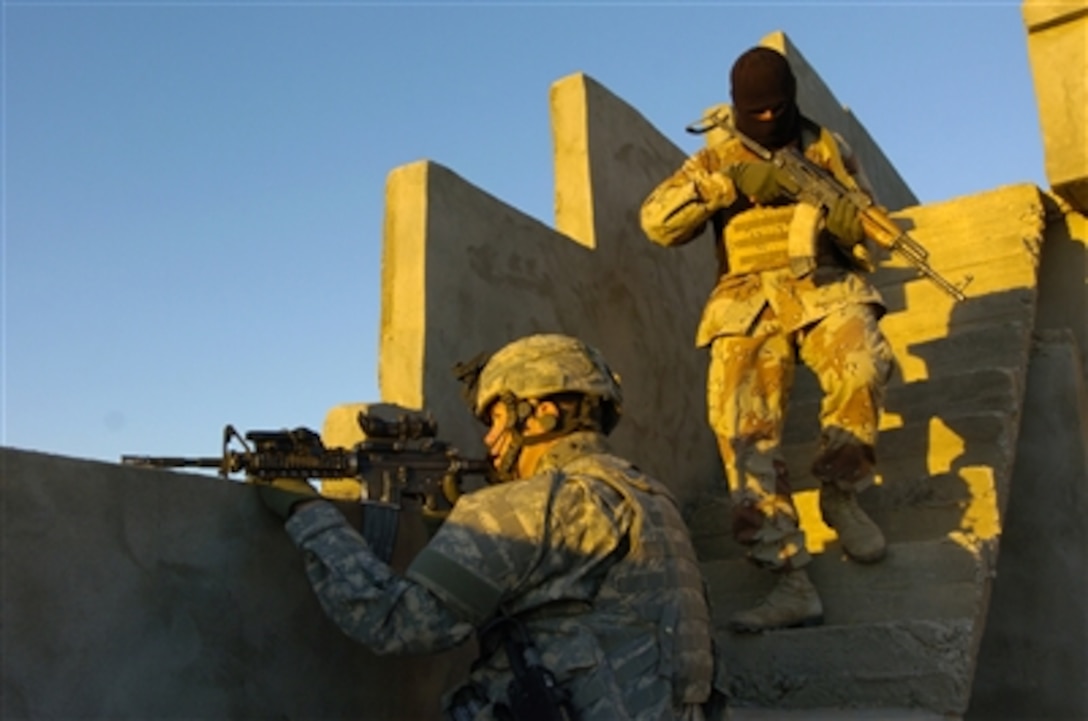 U.S. Army Staff Sgt. Coriey Burkman and an Iraqi army soldier clear the roof of an Iraqi home during a cordon and search operation in Hawijah, Iraq, on Nov. 11, 2006. The soldiers are looking for insurgents, unauthorized weapons and materials for constructing improvised explosive devices.  Burkman is attached to Delta Company, 2nd Battalion, 27th Infantry Regiment.  