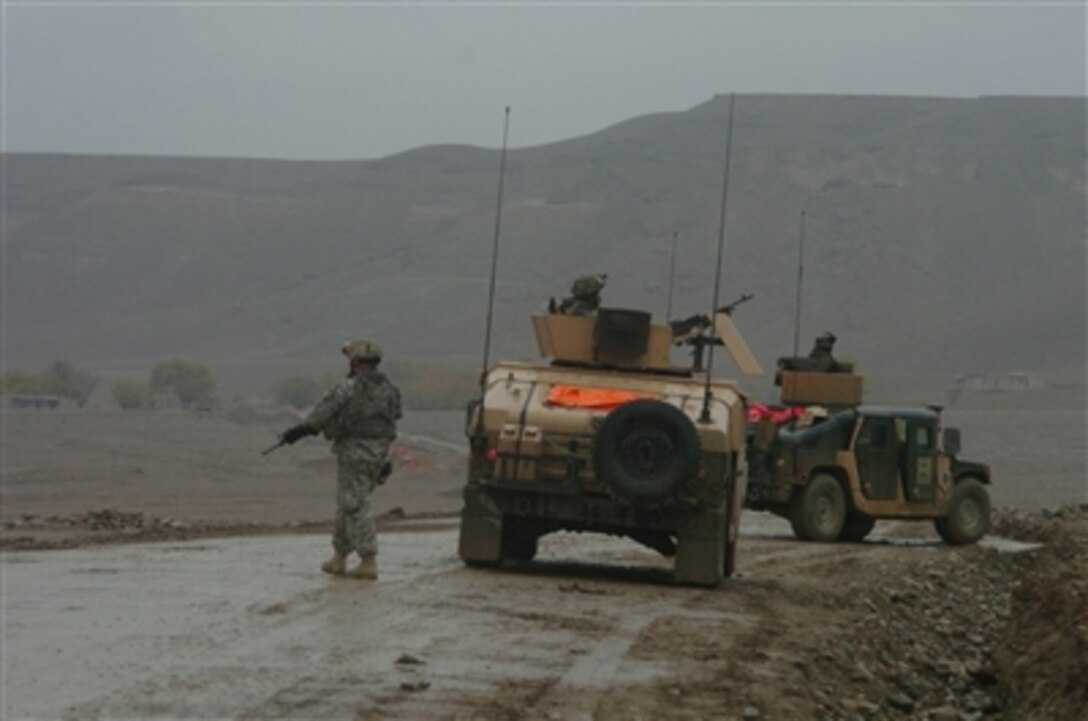 A U.S. Army soldier from the 102nd Infantry Regiment, Connecticut National Guard, attached to Task Force Gauntlet, 10th Mountain Division, pulls security while members of his patrol assess road conditions during a mission in Bagram, Afghanistan, Nov. 16, 2006.
