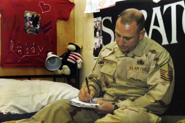 BAGRAM AIR BASE, Afghanistan -- Master Sgt. Timothy Maguire, an Air Force reservist from Westover, writes a letter to his family while deployed thousands of miles from home (US Air Force photo/Capt. Vince King).                    