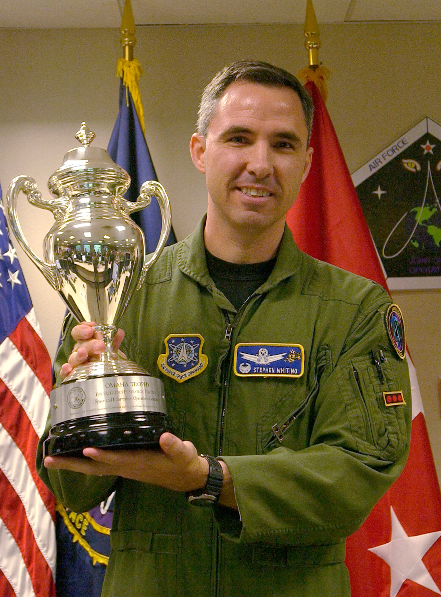 Col. Stephen Whiting, 614th Space Operations Group commander, displays the Omaha Trophy he and his team received for their outstanding performance. The award is presented annually to assigned units that demonstrate the highest standards of performance.  Selection for the award is based on formal evaluations, meritorious achievement, safety and other factors such as community involvement and humanitarian efforts. (U.S. Air Force photo by Airman Stephanie Longoria)