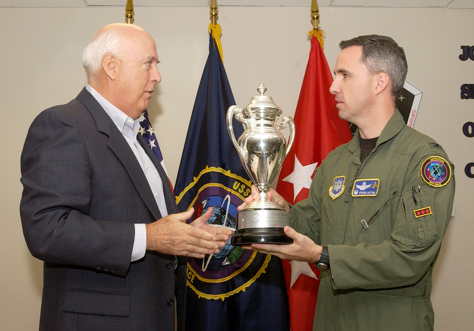 Ken Stinson, U.S. Strategic Command Consultation Committee chairman, presents the Omaha Trophy to Col. Stephen Whiting, 614th Space Operations Group commander, and his team for their outstanding performance. The award is presented annually to assigned units that demonstrate the highest standards of performance.  Selection for the award is based on formal evaluations, meritorious achievement, safety and other factors such as community involvement and humanitarian efforts. (U.S. Air Force photo by Airman Stephanie Longoria)