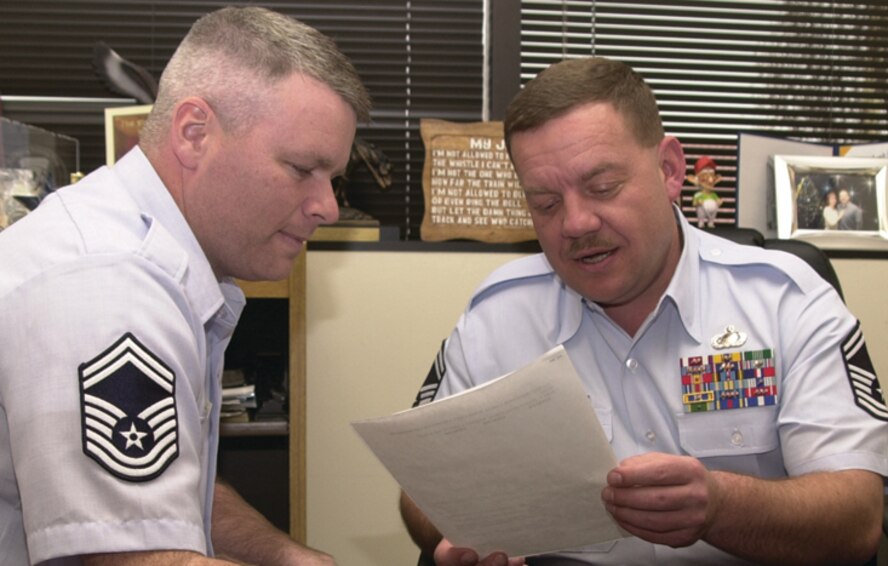 (Photo by Frank McIntyre) Senior Master Sgts. Mark Aman and Don Sibble look over a Vance Top 3 meeting agenda. Both senior NCOs received command-level awards and are competing at Air Force level.