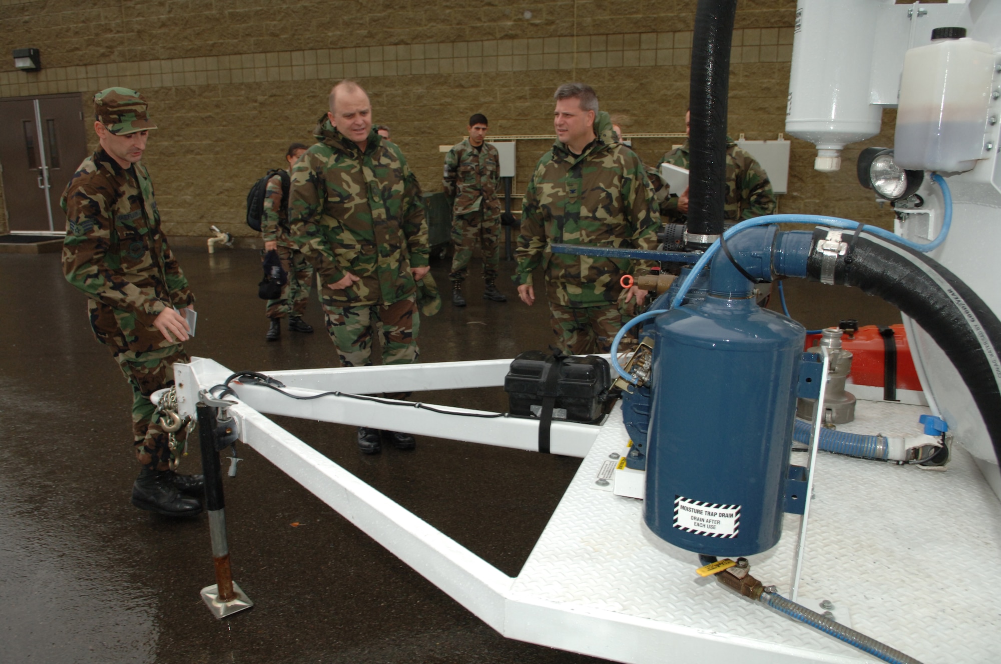 FAIRCHILD AIR FORCE BASE, Wash. -- Senior Airman Thomas Haefliger, 92nd Logistics Readiness Squadron, explains the efficiency of the new vacuum extractor to Col. Joseph Codispoti and Chief Master Sgt. Joseph Hudgins here, Nov. 7. Colonel Codispoti and Chief Hudgins are members of the Penton Team, evaluators from Air Mobility Command headquarters, here to inspect Fairchild’s petroleum, oil and lubrication system. (U.S. Air Force photo/Airman 1st Class Joshua Chapman)