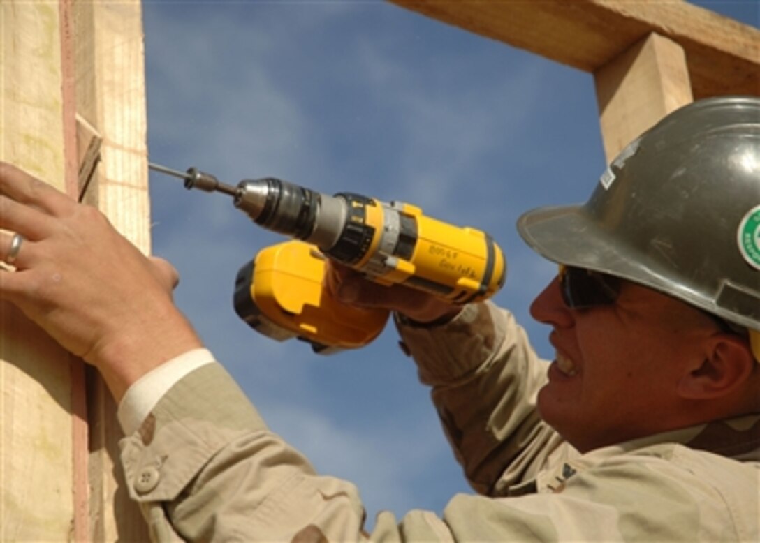 U.S. Navy Petty Officer 3rd Class Mathew Speece of Naval Mobile Construction Battalion 74 secures the frame of a wall at Camp Ramadi, Iraq, Nov. 25.