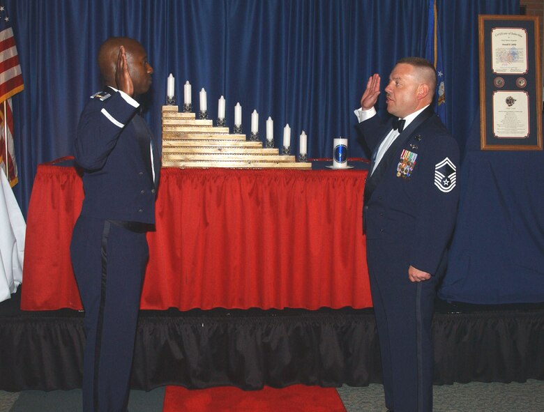 (Photo by Angie Roche) Maj. Devin Washington, 71st Mission Support Squadron, re-enlists Senior Master Sgt. Don Sibble, 71st MSS, during the Chief’s Induction Ceremony Saturday.