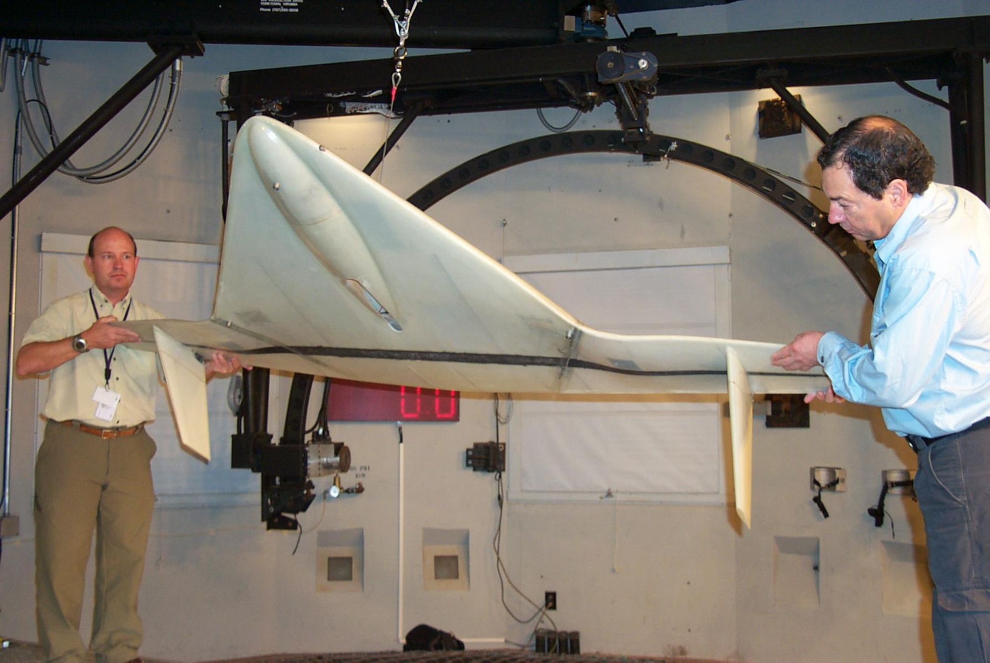 Joe MacKrell (left) of Naval Research Laboratory and Larry Lemke of NASA Ames demonstrate the Vertical Wind Tunnel testing of the Mars Flyer Model. (Air Force photo Holly Jordan)