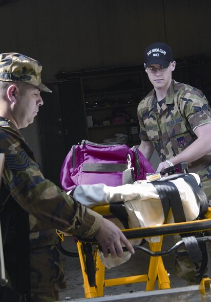 (Photo by Senior Airman Lynne Neveu) Tech. Sgt. Richard Ramos-Gomez and Senior Airman Christian Adams, 71st Medical Group technicians, load a stretcher onto an ambulance.