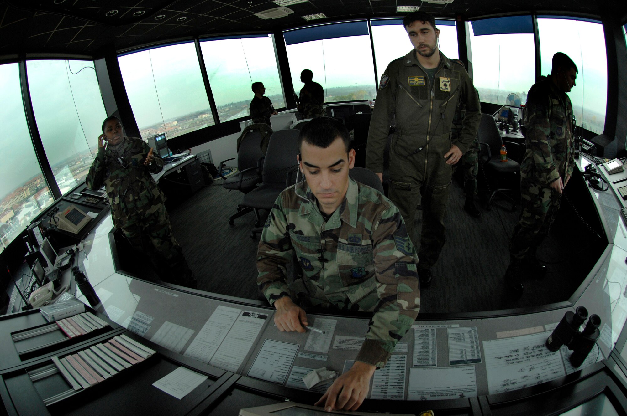 Staff Sgt. Dustin Hodde coordinates the flight plans of multiple aircraft while Italian air force Air Traffic Controller Supervisor Ippolito Maurizio looks on Nov. 28 at Aviano Air Base, Italy. Air traffic controllers perform duties within a radar facility and maintain radar surveillance of approach control airspace, processing and coordinating aircraft through terminal control. Sergeant Hodde is assigned to the 31st Operations Support Squadron. (U.S. Air Force photo/Airman 1st Class Michael S. Dorus)