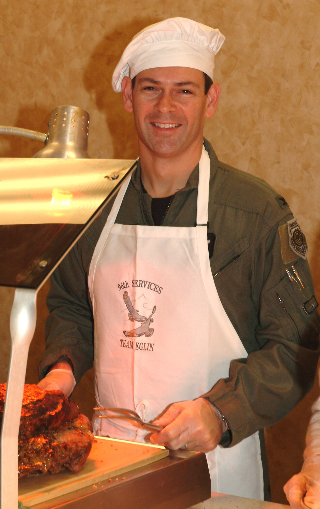 Col. Ken Wilsbach, 53d Wing commander, carved up some prime rib at the dining facility Thanksgiving Day.  Colonel Wilsbach’s wife, Cindy, also helped serve.  (Photo by Staff Sgt. Samuel King Jr.)