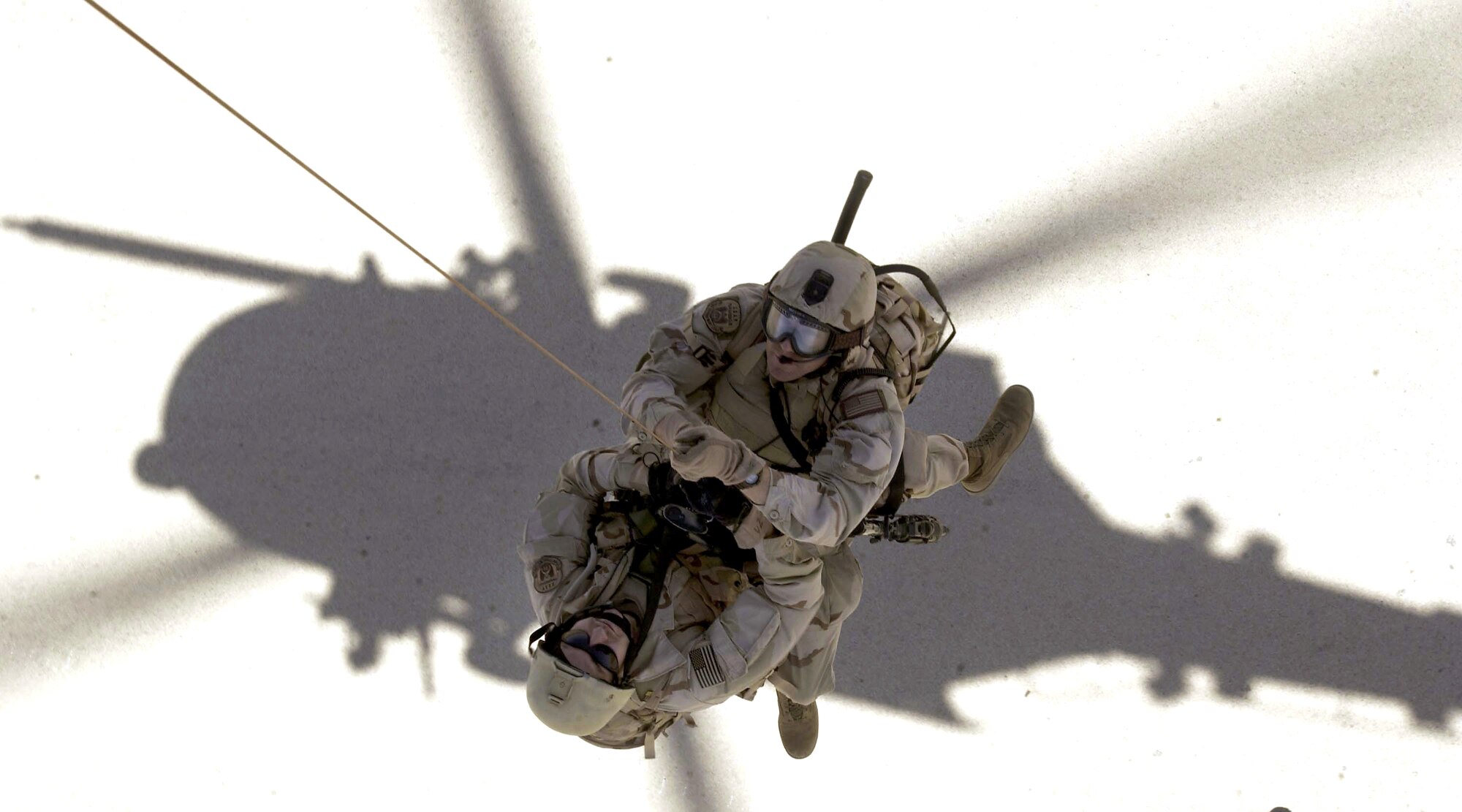 Pararescuemen from the 304th Rescue Squadron are hoisted up to an HH-60G Pavehawk during Operation Iraqi Freedom in April 2003 at Tallil Air Base, Iraq. (U.S. Air Force photo/Tech. Sgt. Shane A. Cuomo) 