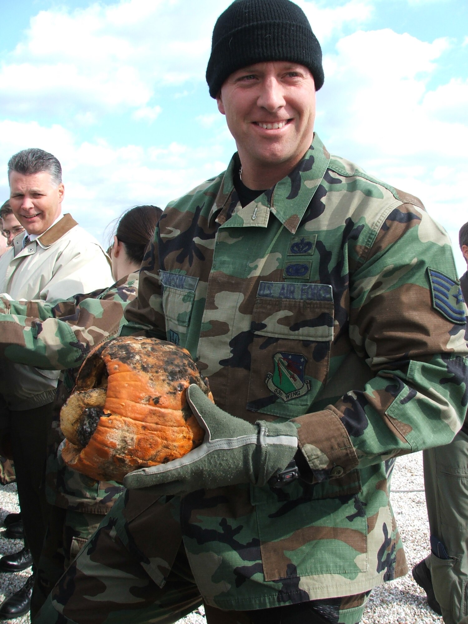 Tech. Sgt. Daniel Simpson, 28th Test and Evaluation Squadron, takes a whiff of his decaying pumpkin before tossing it over Bldg. 350 during the 3rd Annual Joint Direct Attack Pumpkin drop Nov. 20.  (Photo by Tech. Sgt. Andrew Leonhard)