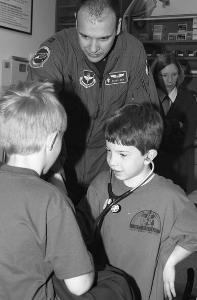 (Photo by Staff Sgt. Amanda Mills) Capt. (Dr.) Peter Kah, 71st Medical Group, helps his son Konnor listen to a classmate’s heart during a tour April 1.
