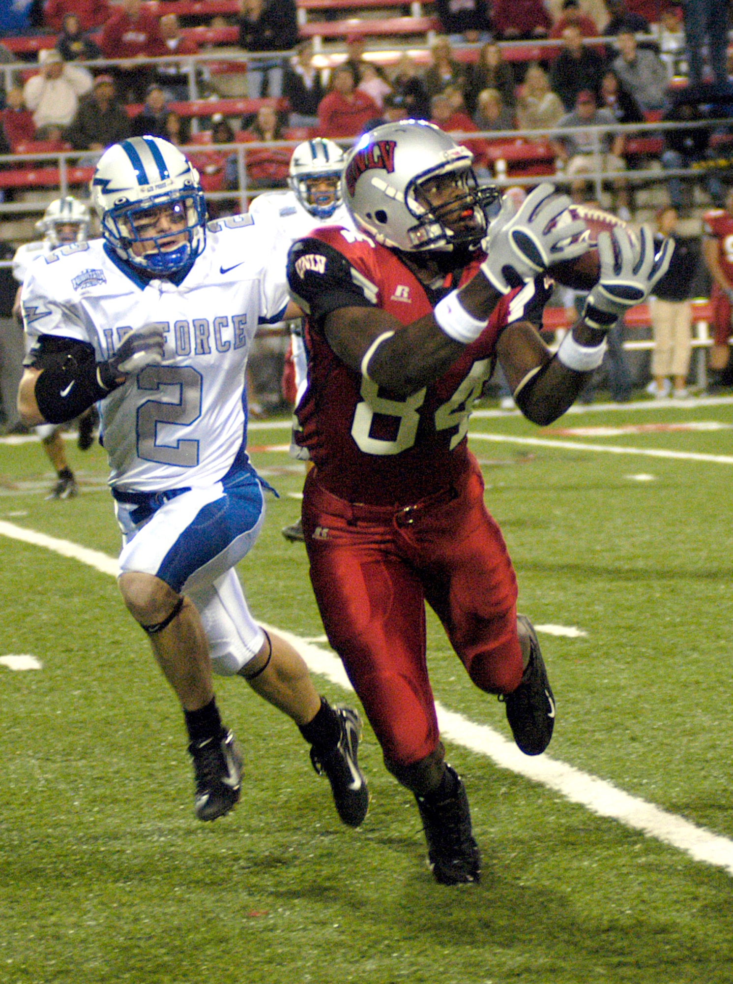 University of Nevada-Las Vegas tight end Rodelin Anthony, 84, hauls in a pass against Falcons cornerback Carson Bird Nov. 24 at Las Vegas.  Anthony finished the night with two catches for 35 yards as the Rebels picked up their second win of the season 42-39. (U.S. Air Force photo/Cadet 2nd Class Paul Russo)