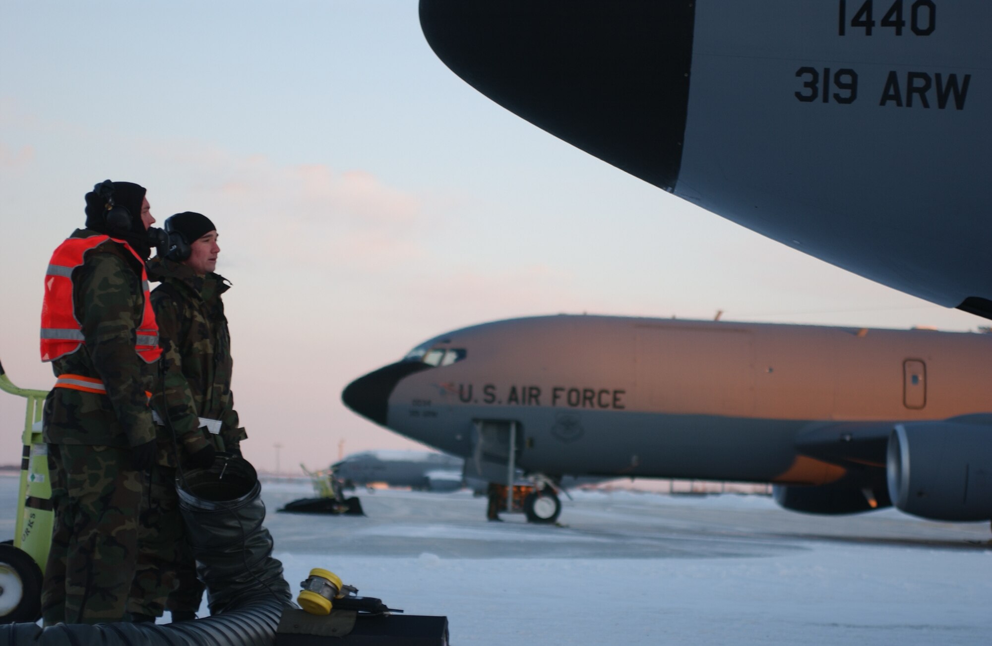 319th Aircraft Maintenance Squadron Airmen warm themselves by a heater on the flightline after fixing one of the jets Wednesday morning. Tuesday morning was the first significant snow fall of the winter with the coldest temperature so far this year. (photo/Airman 1st Class Ashley Coomes)