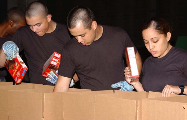 From left, Airman Basic Steven Hyden, Airman 1st Class Thomas Hubble and Airman Basic Dianna Gonzalez, 336th Training Squadron students, pack holiday food boxes Monday for the Salvation Army angel tree at the agency’s warehouse in Biloxi. Fifteen students from several training squadrons packed nearly 1,500 boxes in about 5 1/2 hours. (U.S. Air Force photo by Kemberly Groue)